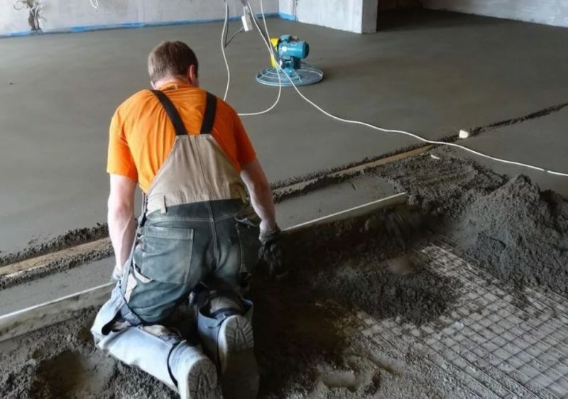 Мастер заливает бетонный пол